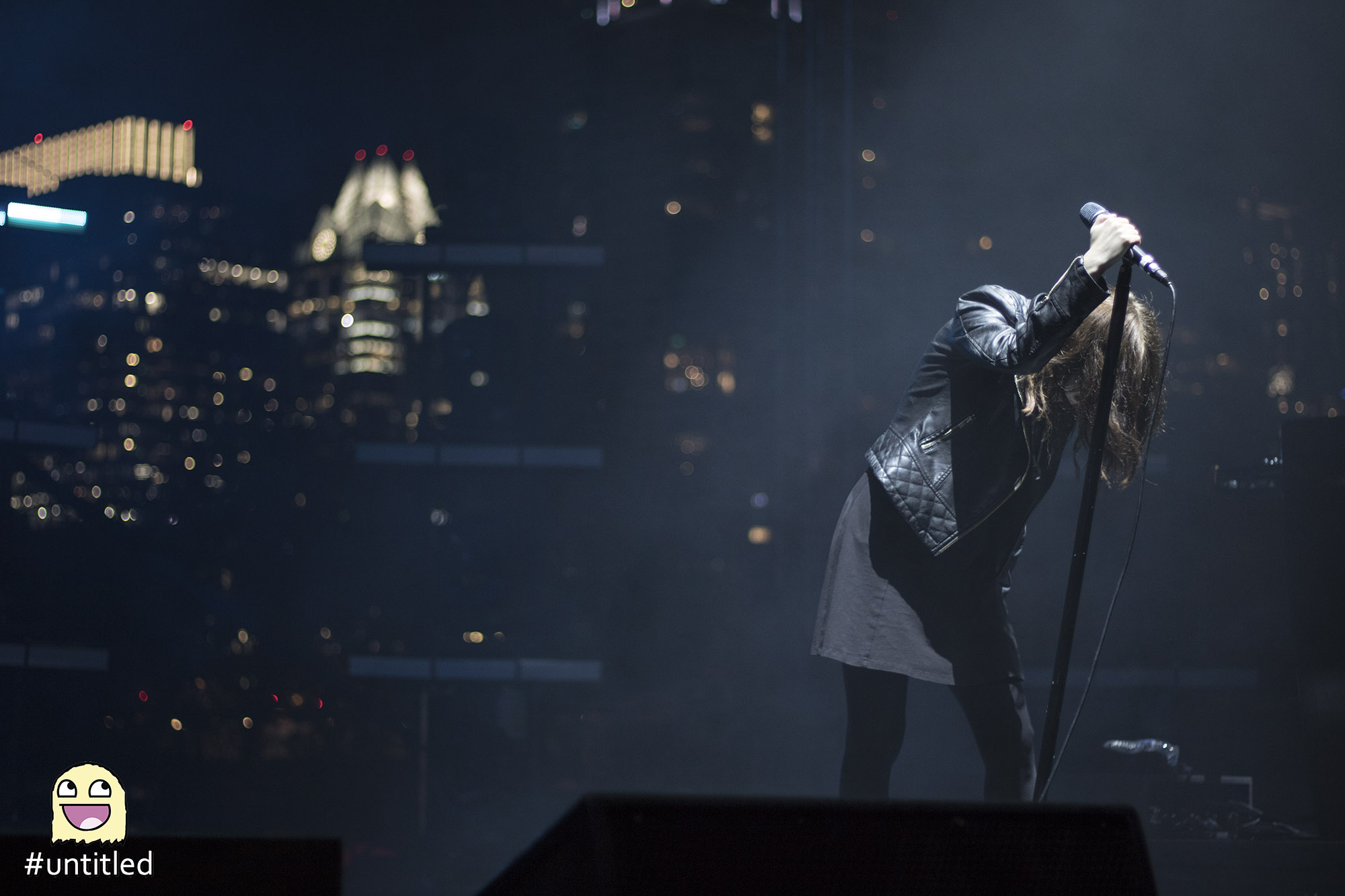 Chvrches holding microphone looking down